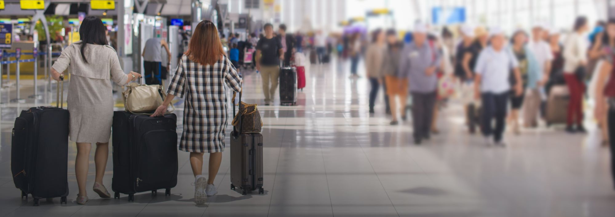 Image of people walking in airport with suitcases